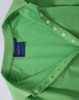 A green Ladies' Truedry Pique Polo shirt features a polo collar and button detail, with a brand label visible.