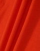 An orange fabric with a textured surface, showcasing the material of the Ladies' Truedry Pique Polo.