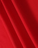 A red fabric with a textured surface, showcasing the material of a polo shirt. It has a logo in the corner.