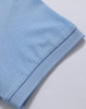 A light blue polo shirt with a textured finish, featuring a folded sleeve and a branding logo.