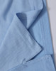 A close-up of a light blue polo shirt, highlighting the fabric texture and stitching details. The shirt features a logo.