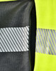 A bright yellow work jumper featuring reflective stripes and a zipper pocket in a contrasting dark grey fabric.