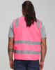 A pink safety vest featuring shoulder reflective tapes and grey stripes, worn by a person from behind.