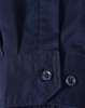 A close-up of a blue long-sleeve shirt featuring segmented tape, with a buttoned cuff detail.