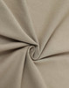 A close-up of beige premium cotton fabric, showcasing a smooth texture and soft, folded appearance.