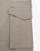 A close-up of a beige work pant pocket featuring a flap, showcasing the fabric texture and stitching detail.