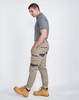 Unisex cotton stretch drill cuffed work pants in light beige with a logo, paired with a grey polo and yellow boots.