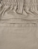 A close-up of beige unisex cotton stretch drill work shorts, featuring an elastic waistband and a pocket.