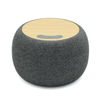 A round, grey wireless speaker with a bamboo top and control buttons, featuring a logo on the surface.