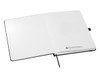 An open A5 notebook with blank white pages and a black cover, featuring a logo on the inner page.
