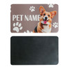 A pet feeding mat with a smiling dog illustration and paw prints, featuring a textured black reverse side.