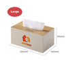 A large tissue box with a light beige fabric exterior and wooden top, featuring a logo. Dimensions are listed.