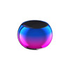 A round, mini bass wireless speaker in a vibrant gradient of blue and pink colours with a black speaker top.