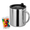A stainless steel coffee mug with a black lid alongside a pack of colourful jelly beans.