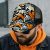 A mesh cap featuring a vibrant floral pattern in orange, blue, and cream, worn by a man with sunglasses.