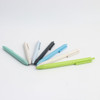 Wheat straw ballpoint pens in green, blue, black, and cream arranged in a circular pattern on a light background.