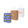 Three paper bags: one with a blue space theme, a kraft paper bag, and a white bag with an orange logo.