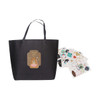 A medium black boutique paper bag with a bear illustration and multiple decorative stickers beside it.