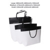 Three boutique paper bags in black and white, featuring varying sizes and handles. One bag has a logo.