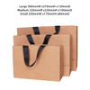 Three brown paper bags with flat black handles in various sizes: large, medium, and small.