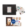 A large black paper bag with a fabric flat handle, featuring assorted stickers and design elements.