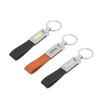 Three keyrings featuring PU leather straps in black and orange, with metal connectors and branding.