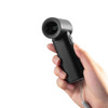 A black handheld fan is being held in a hand, featuring a sleek design and a small button.