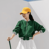 A green bomber jacket with white striped cuffs, paired with a yellow cap that features a logo.