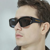 Wraparound sunglasses in black with a sleek design, worn by a model. The sunglasses feature a small logo on the side.