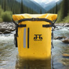 A waterproof roll top backpack in bright yellow, featuring straps and a logo, sits in a river surrounded by trees and mountains.