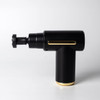 A black massage gun with gold accents, featuring an adjustable head and a sleek design. It has a logo on the side.