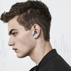 Active noise cancelling wireless earbuds in blue, worn in the ear of a young man with short hair against a neutral background.