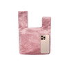 A pink velvet wrist bag with a smooth texture, featuring a phone next to it for size comparison.