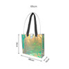 An iridescent clear tote bag with black straps, featuring measurements of 66cm x 38cm x 10cm.