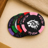 A set of black poker chips with colourful accents in green, purple, pink, and a lion logo in the centre.