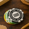 A set of colourful poker chips in white, green, yellow, and black, featuring various numerical values.