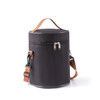 A cylindrical black lunch bag with a zipper closure and a detachable shoulder strap. It has a handle and branding.