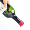 A drink bottle with a red silicone wine stopper securely fitted at the opening, held by a hand.
