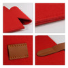 A red felt wine bag featuring a brown leather strap and stitching details, with a smooth texture and clean edges.