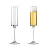 Two straight champagne flutes, one empty and one filled with bubbly golden champagne, both featuring a logo.