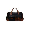 A vintage canvas duffle bag in black with brown leather accents and two front pockets. Features a logo.