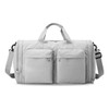 A foldable travel duffle bag in light grey with two front zippered pockets and a detachable shoulder strap.