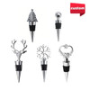 A collection of five wine stoppers featuring a deer head, Christmas tree, snowflake, heart, and a ball design, in metallic colours.