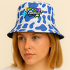 A bucket hat with a blue and white cow print design and a logo on the front.