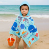 A hooded towel featuring a blue and aqua design with ocean-themed graphics. It has a logo and is worn by a child at the beach.