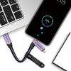 A 60W 6-in-1 braided charging cable in purple, connected to a smartphone and a laptop, with a keyring attachment.