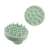 A green hair scalp massager with textured spikes for stimulating the scalp, featuring a circular design.