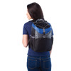 A backpack cooler in black and blue, featuring a logo, worn by a woman from the back.