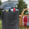 A drink bottle cooler in black, featuring multiple bottles inside, with a picnic basket in the background.