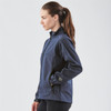 A navy women's jacket with a zip front, featuring a high collar and side pockets. The model is shown from the side.